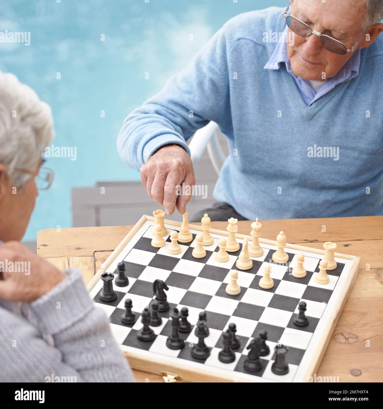 Passing the time with an engrossing game of chess. An elderly couple playing a game of chess. Stock Photo