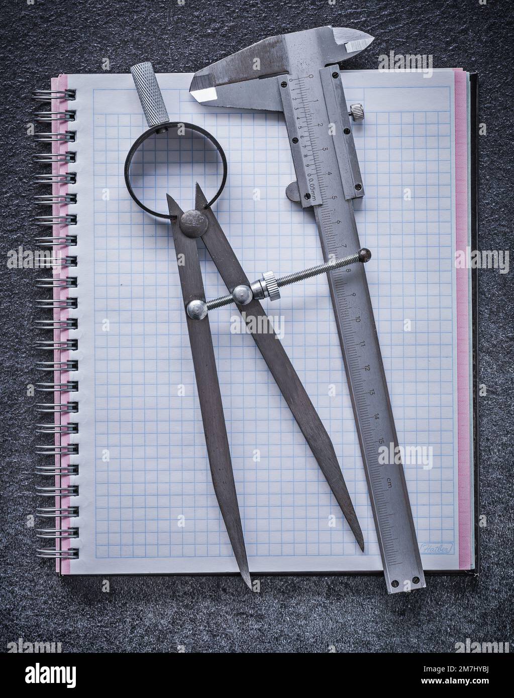 Drawing compass slide caliper notebook on black background construction