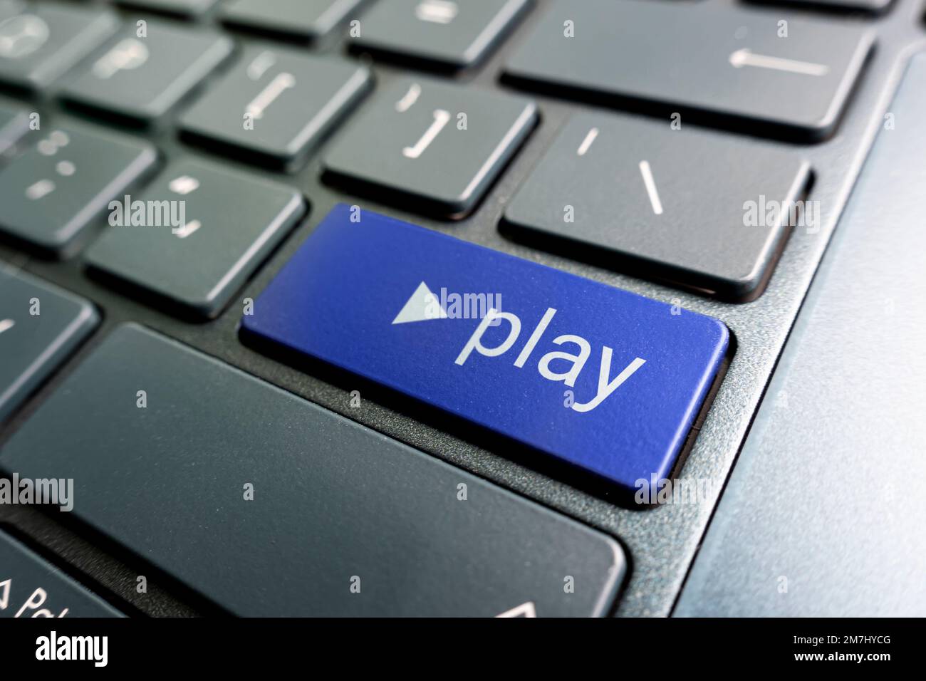 A colored button with the inscription play on a black keyboard. Stock Photo
