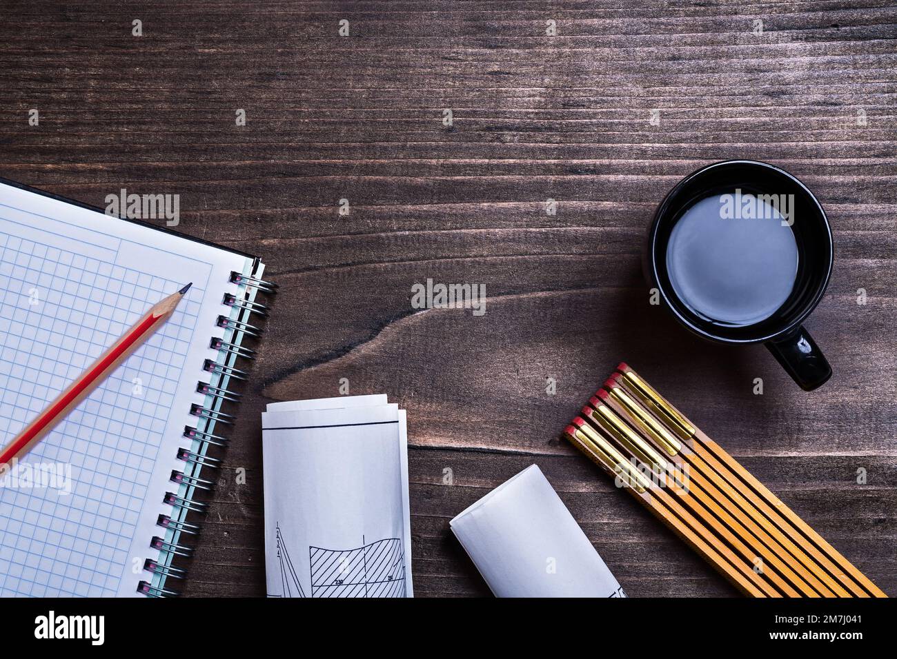 Notepad pencil construction drawings wooden meter and cup of coffee on