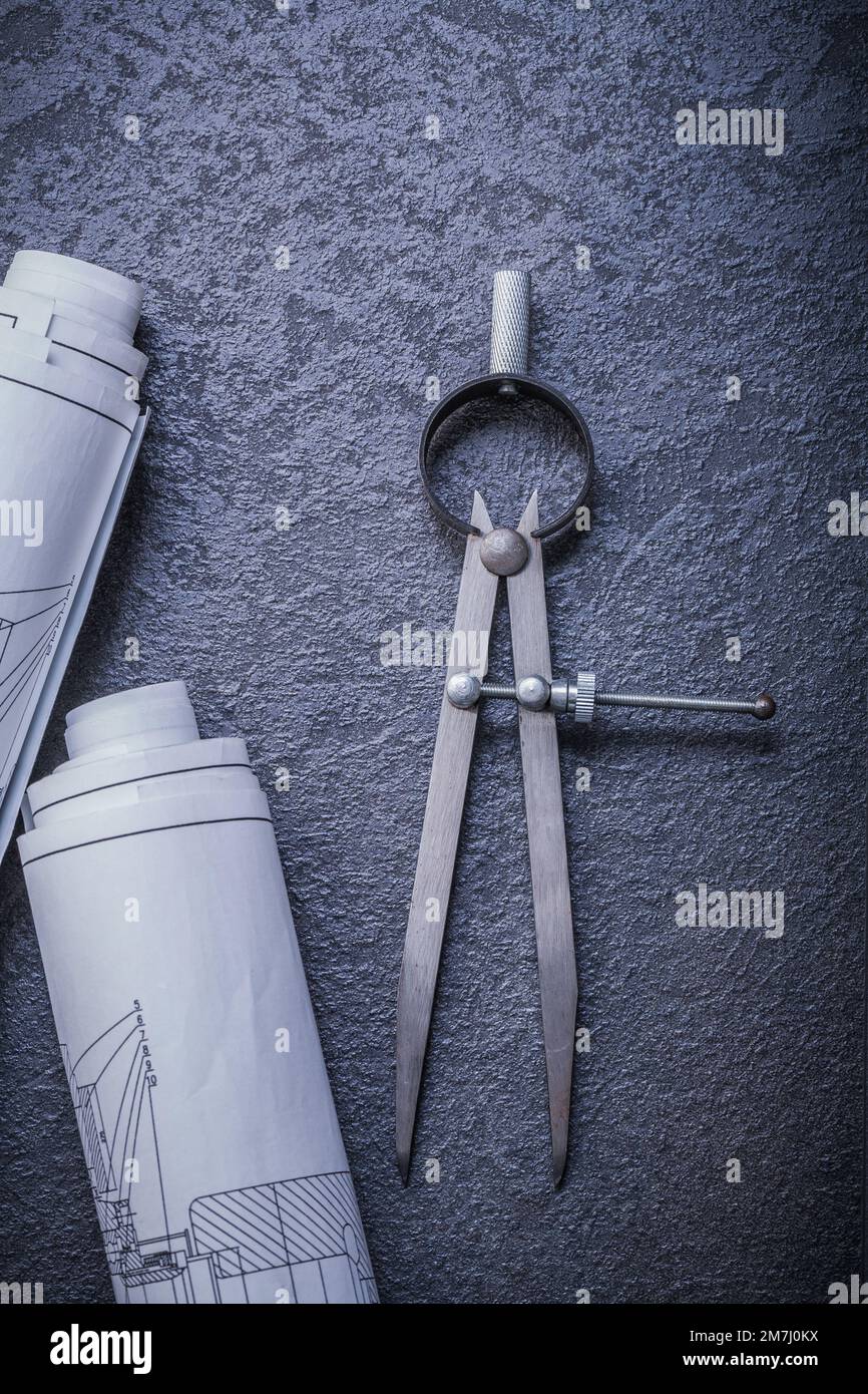 Rolled blueprints divider on black background maintenance concept. Stock Photo