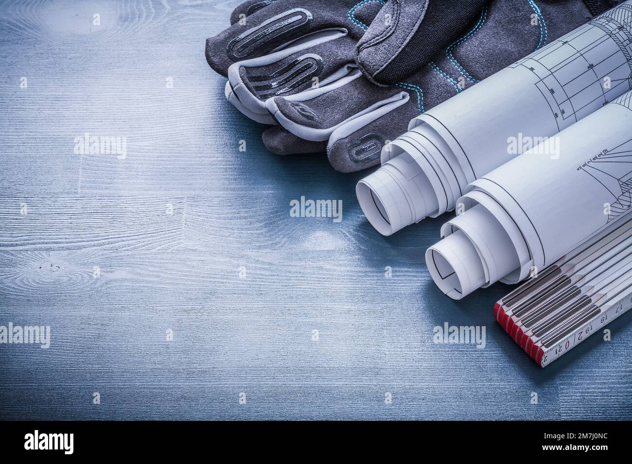 rolled blueprints wooden meter and protective working gloves Stock ...