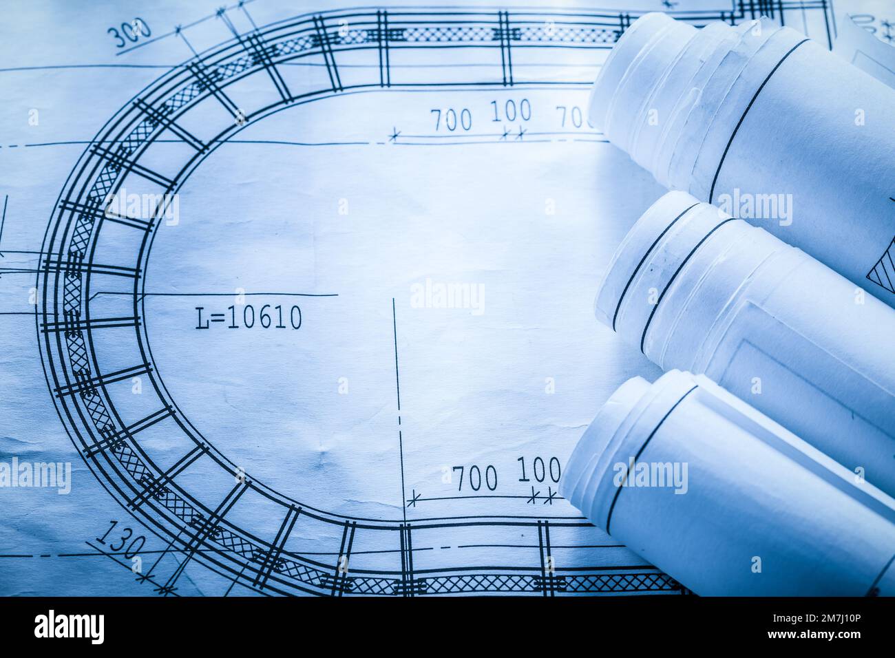 Rolled up construction plans on blueprint top view. Stock Photo