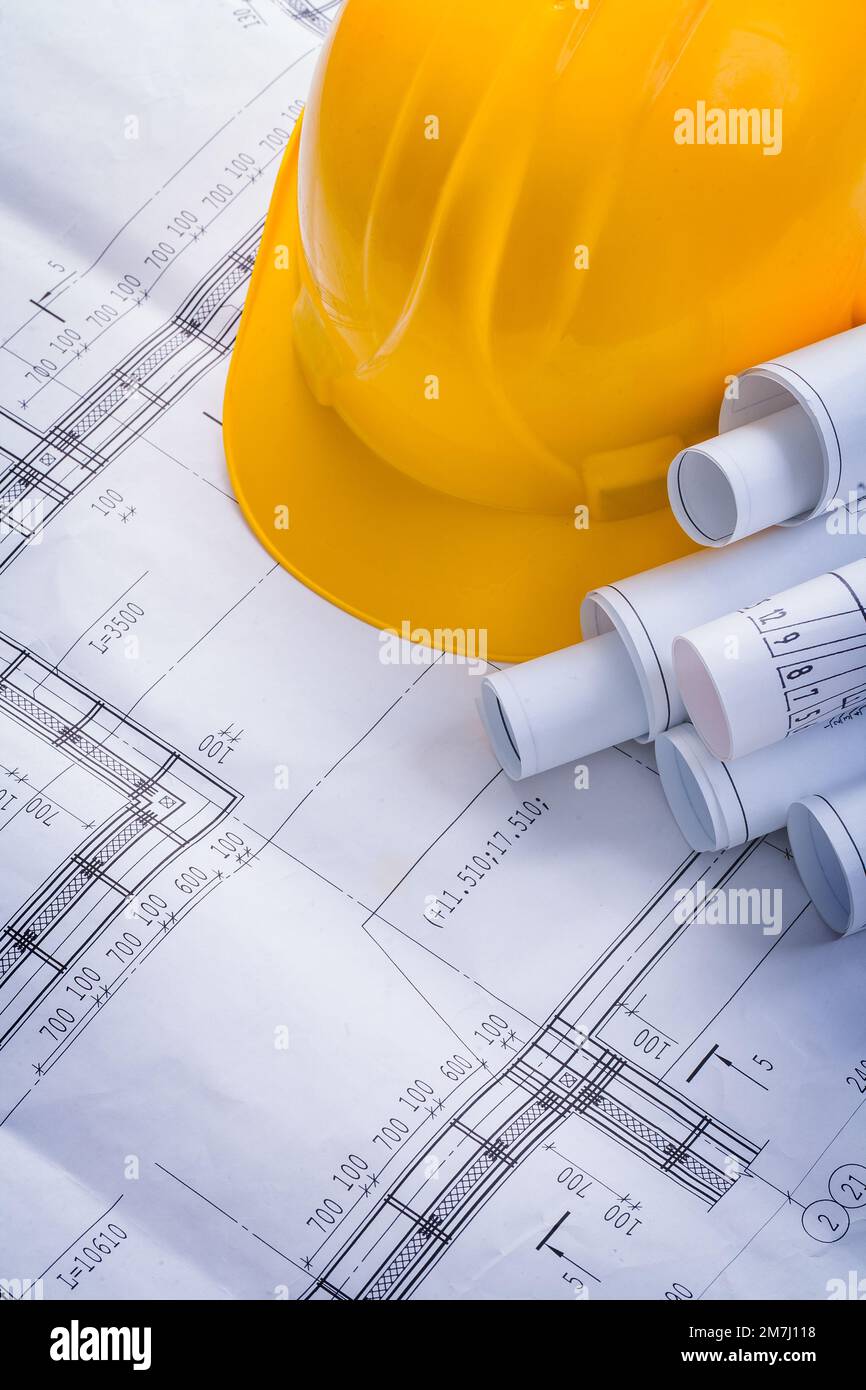 rolls of blueprints and yellow helmet Stock Photo - Alamy