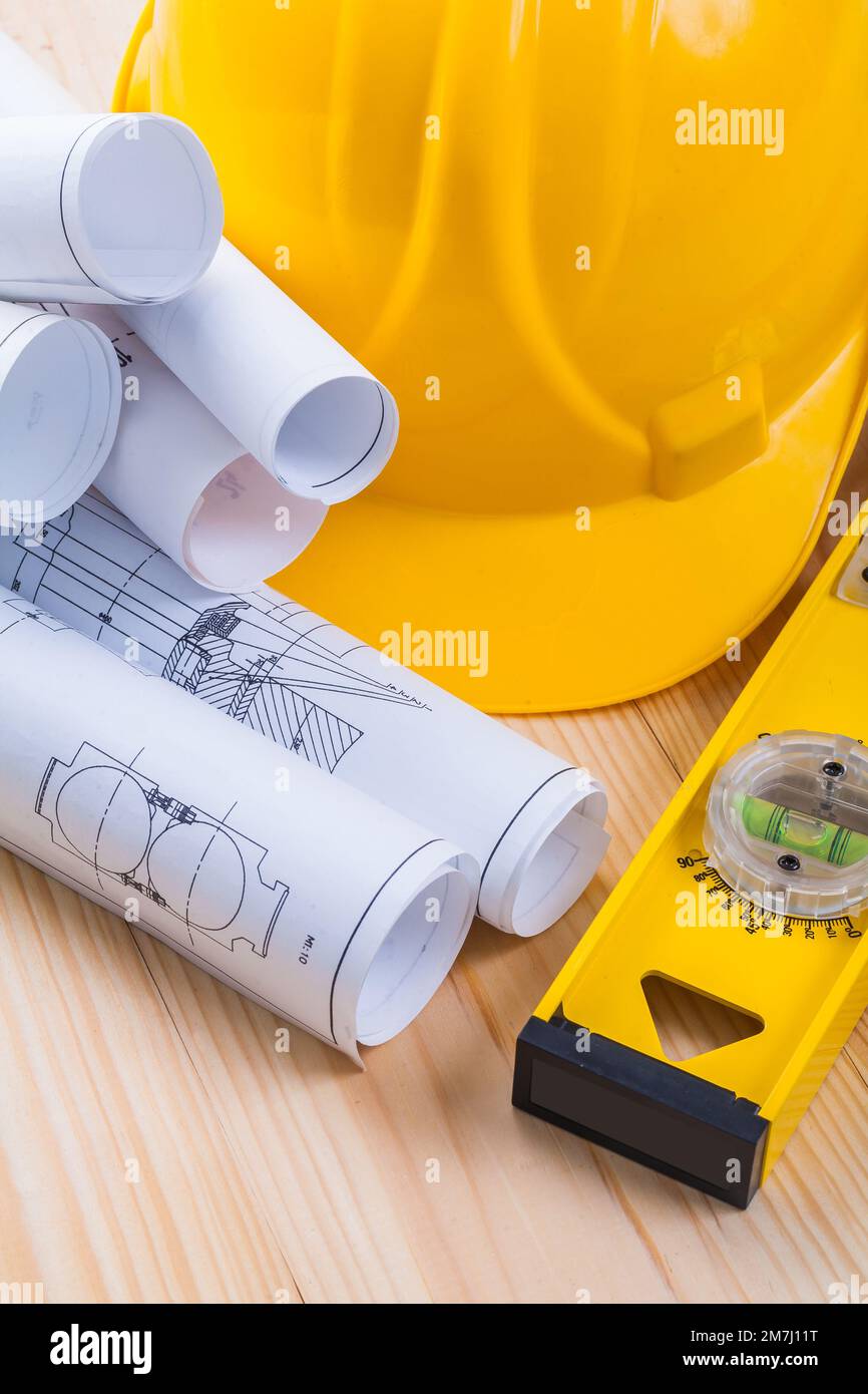 rolls of blueprints helmet and yellow construction level Stock Photo ...