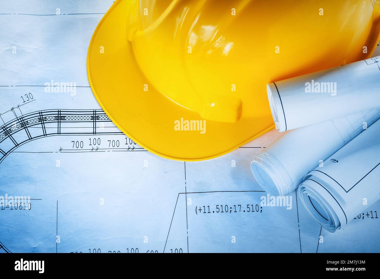 Safety building helmet construction plans on blueprint Stock Photo - Alamy