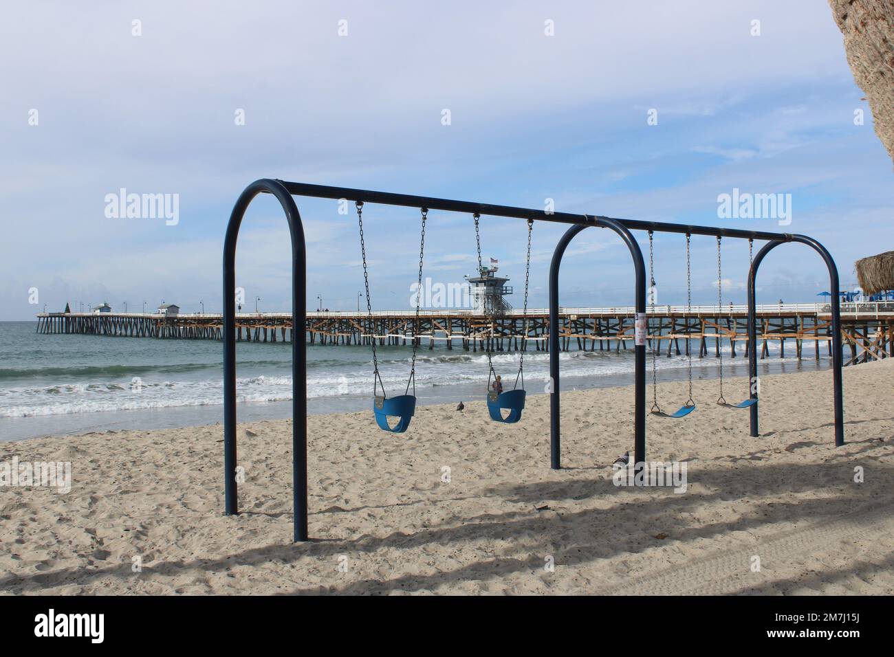 Empty children's swing set on San Clemente State Beach, California Stock Photo