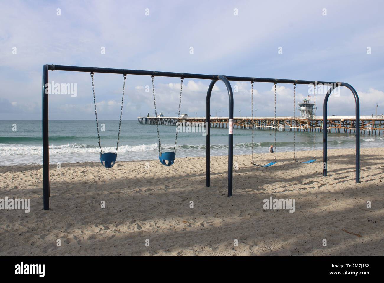 Empty children's swing set on San Clemente State Beach, California Stock Photo