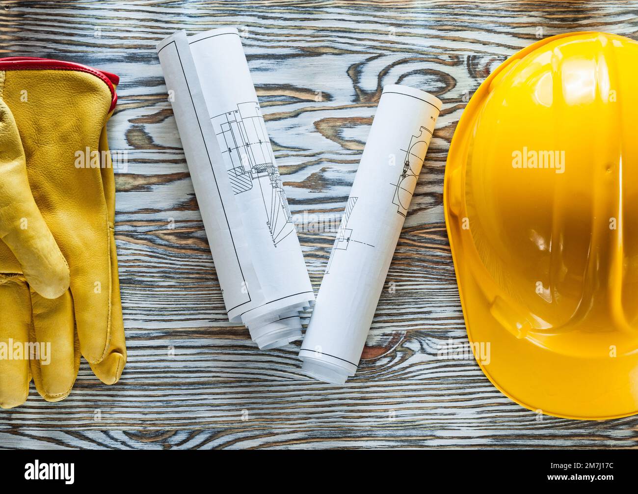 Safety gloves hard hat blueprints on wooden board Stock Photo - Alamy
