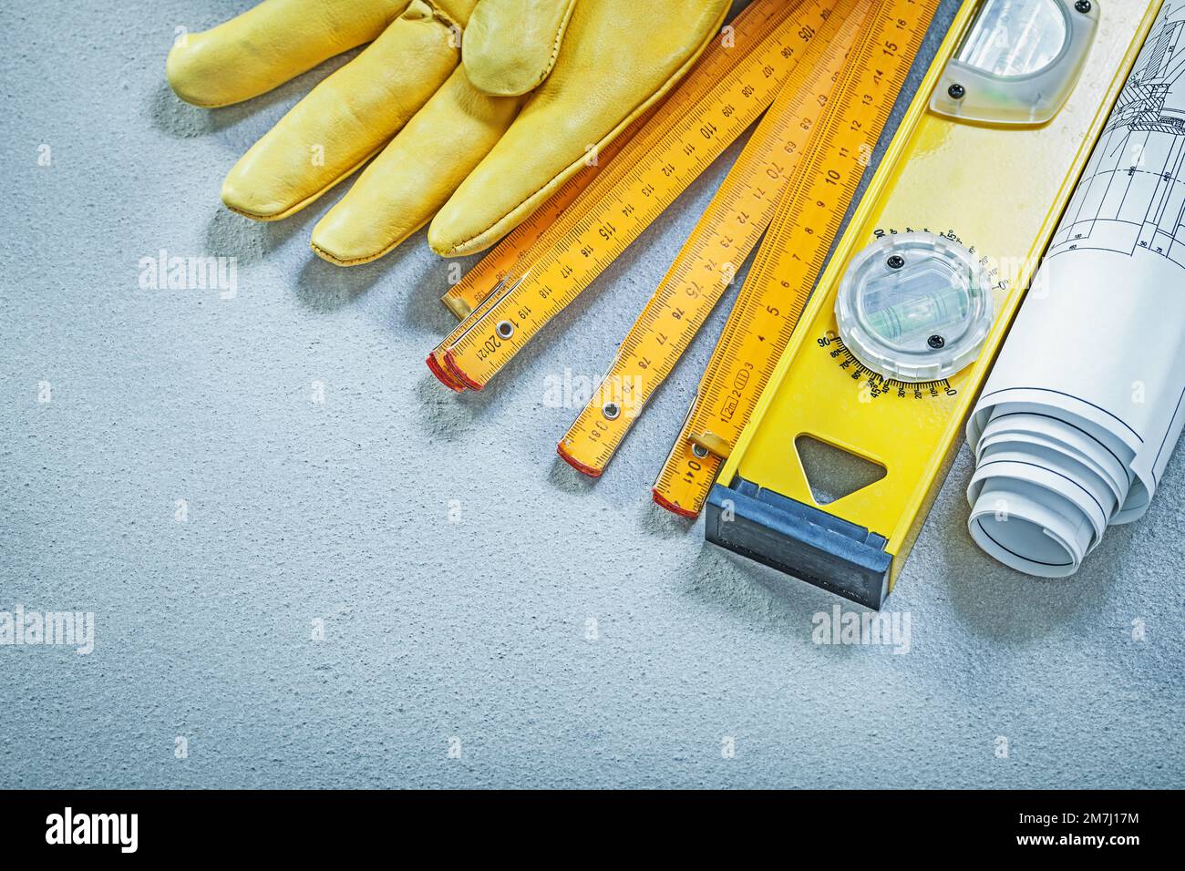 Safety gloves construction level wooden meter blueprints on concrete ...