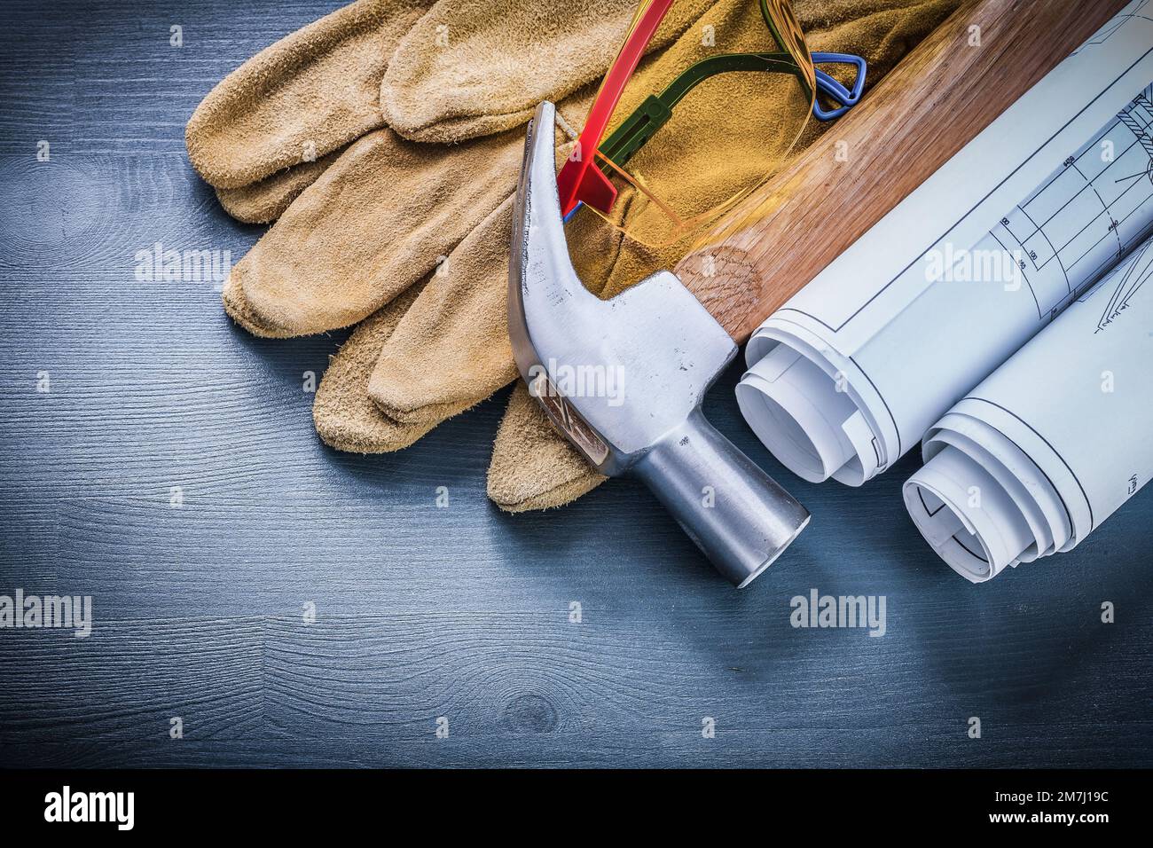 safety gloves rolled blueprints hammer goggles Stock Photo - Alamy