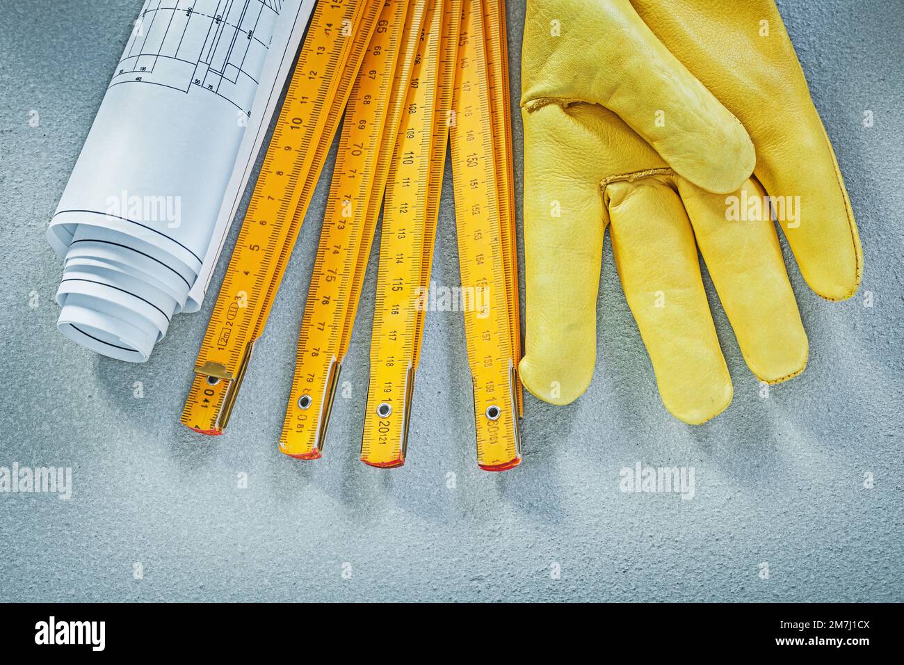 Set of safety gloves construction drawings wooden meter on concrete ...