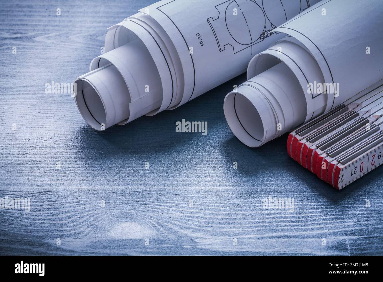 two rolls of blueprints and white wooden meter Stock Photo - Alamy