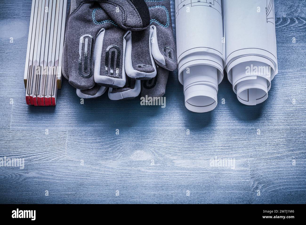 two rolls of blueprints safety gloves and wooden meter Stock Photo - Alamy