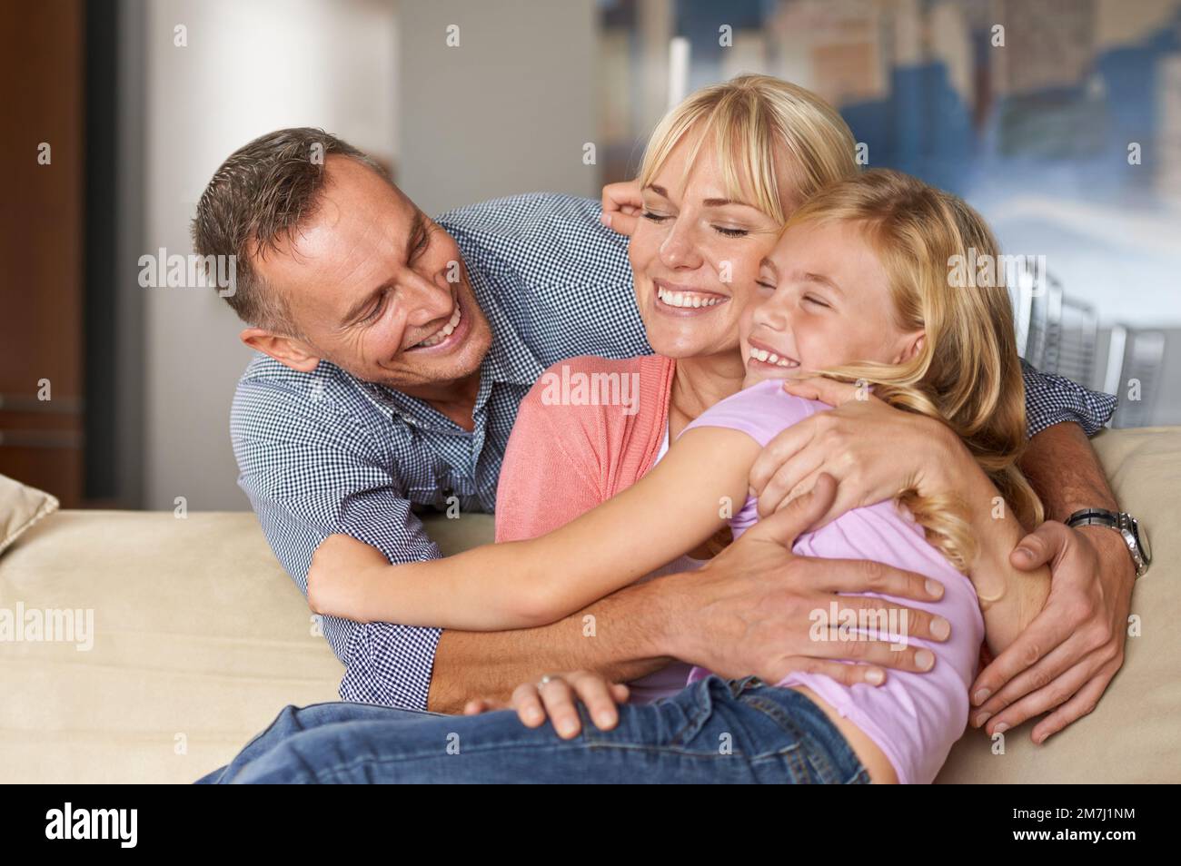 Treasure these moments. a loving family embracing each other on the sofa. Stock Photo