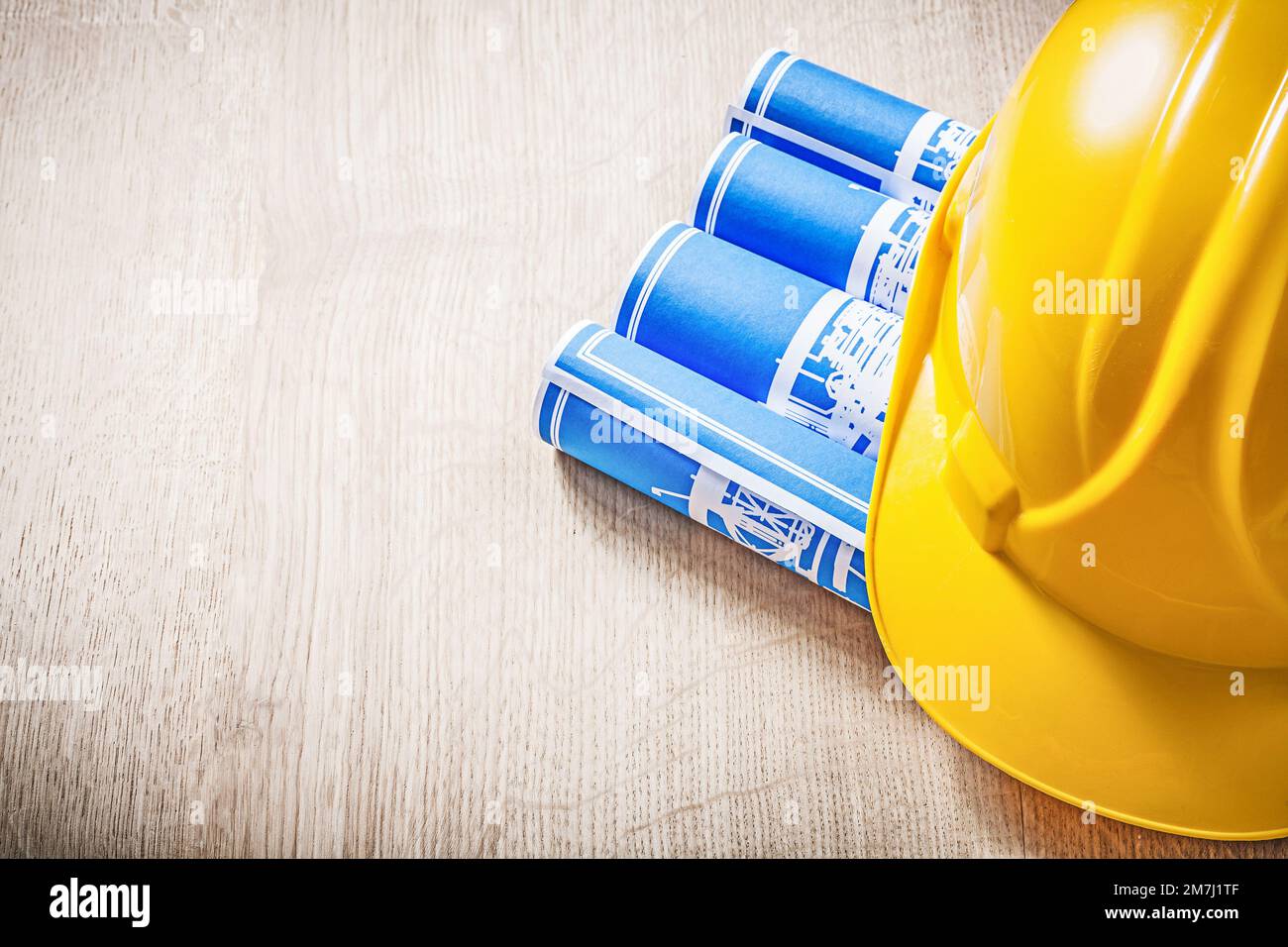 Wooden board with blue rolled construction drawings safety helmet Stock ...