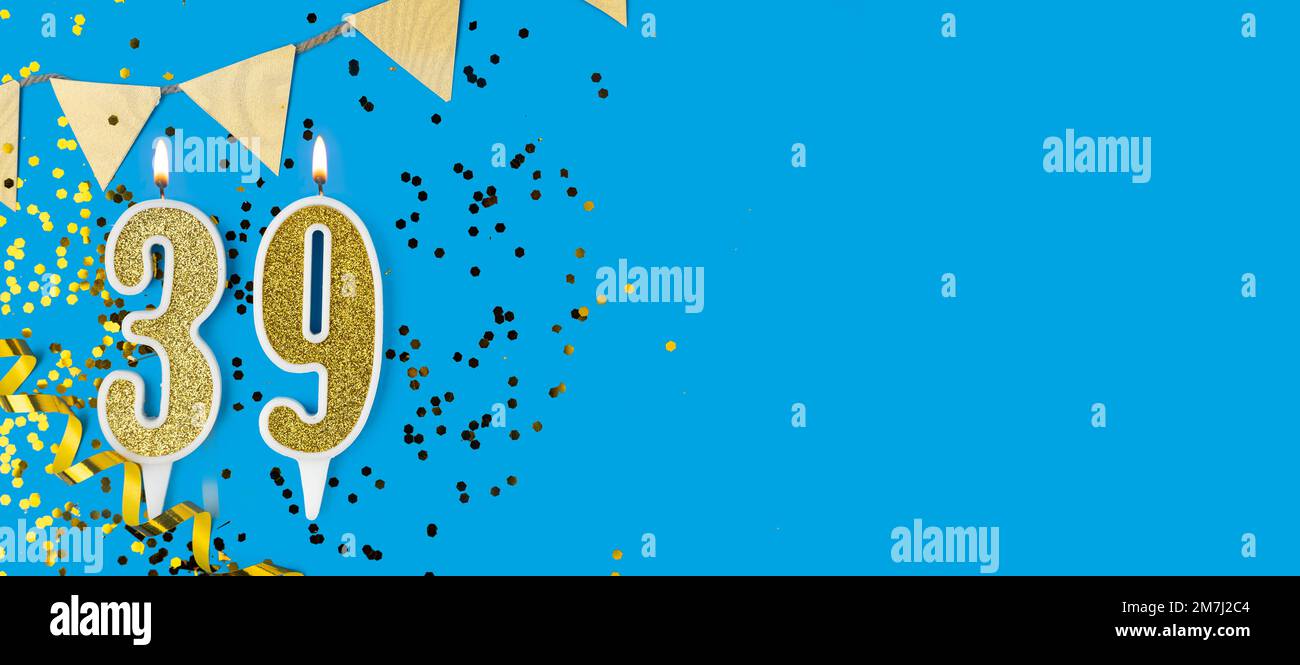 Number 39 gold celebration candle on blue background. Copy space. Stock Photo