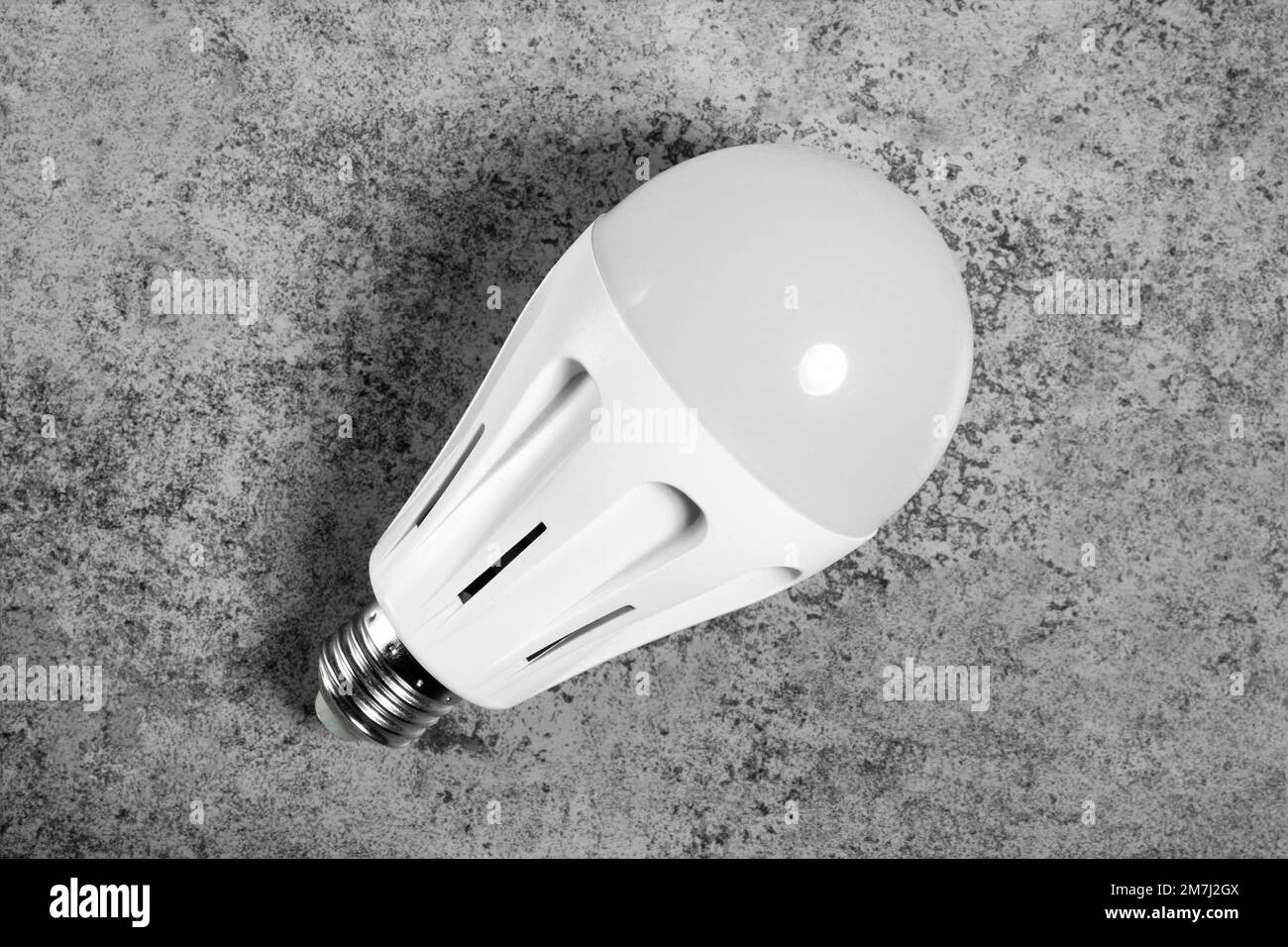 LED energy-saving lamp with E27 screw cap base on gray background Stock Photo