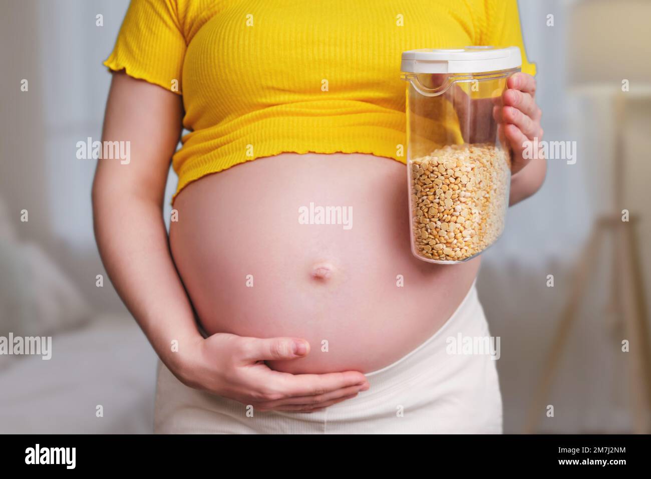 A pregnant woman holds a can of beans in her hand Stock Photo Alamy