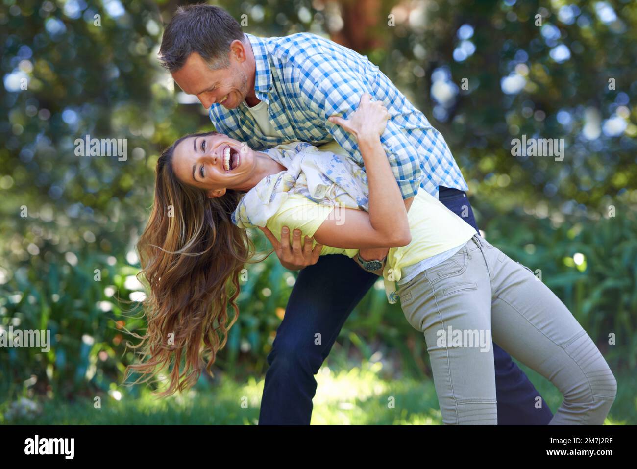 He sweeps me off my feet. An affectionate couple outside in the summer ...