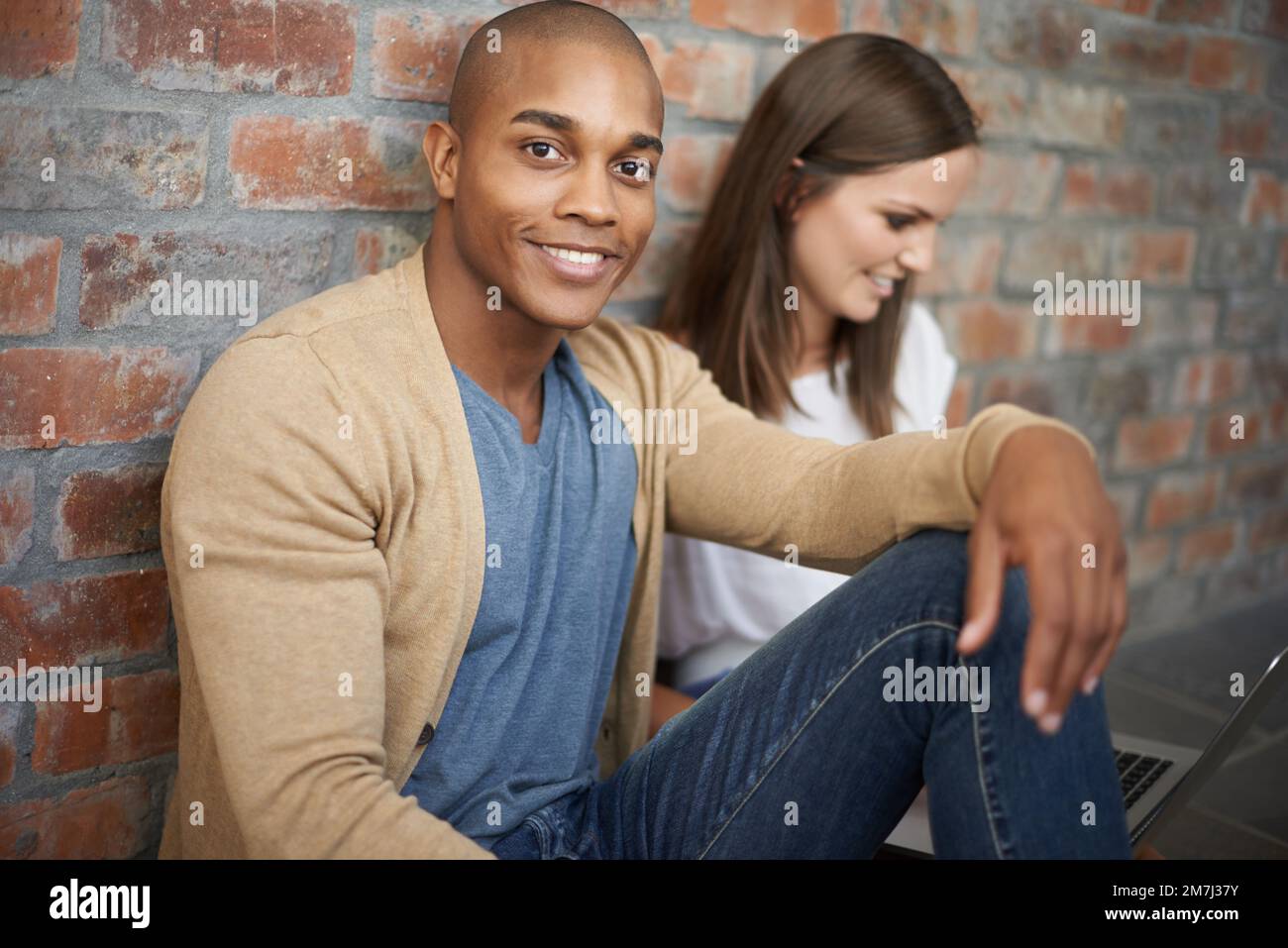 Relaxing with a friend. two friends sitting together in a hallway. Stock Photo