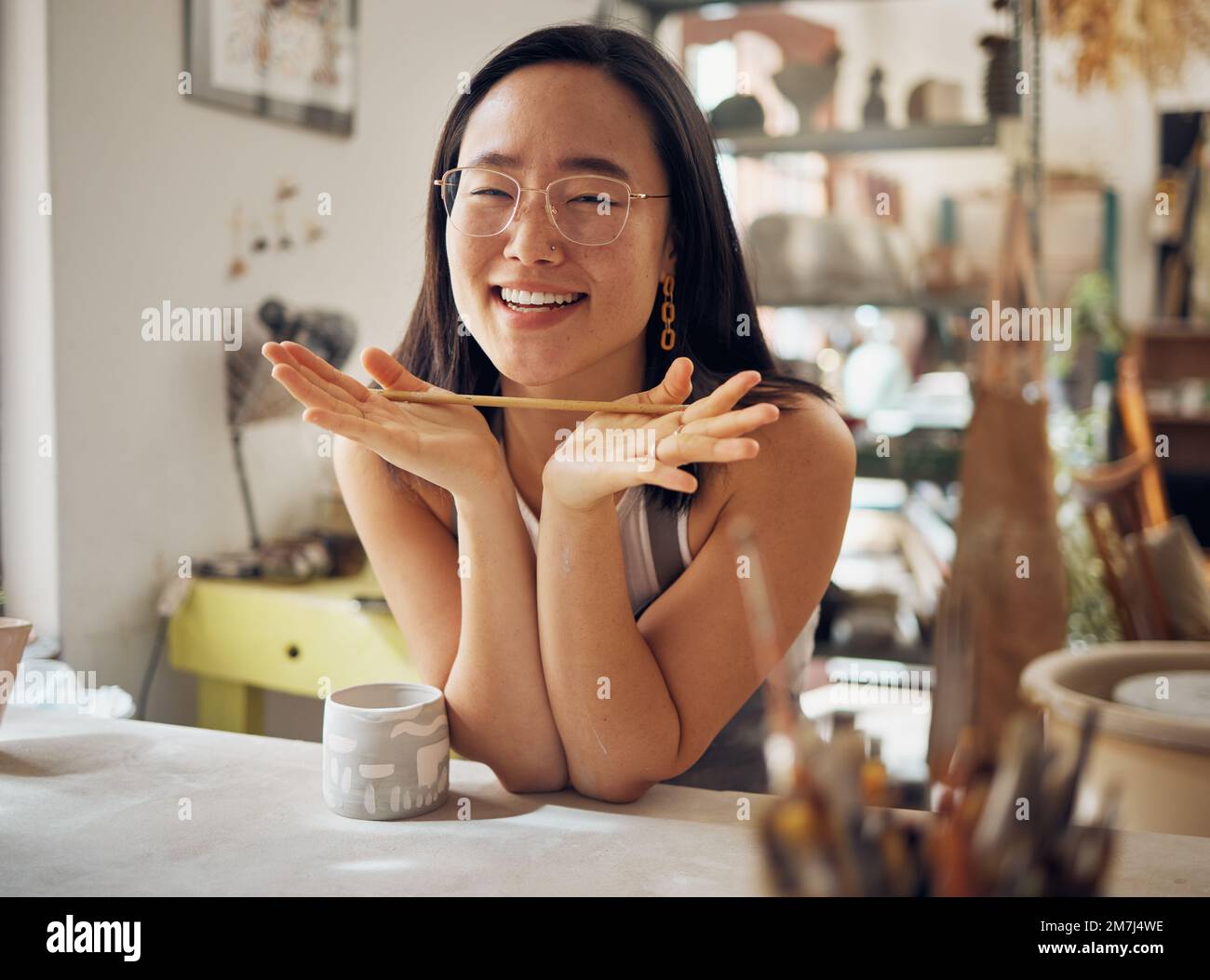 Portrait, pottery and art with an asian woman in her studio or workshop ...