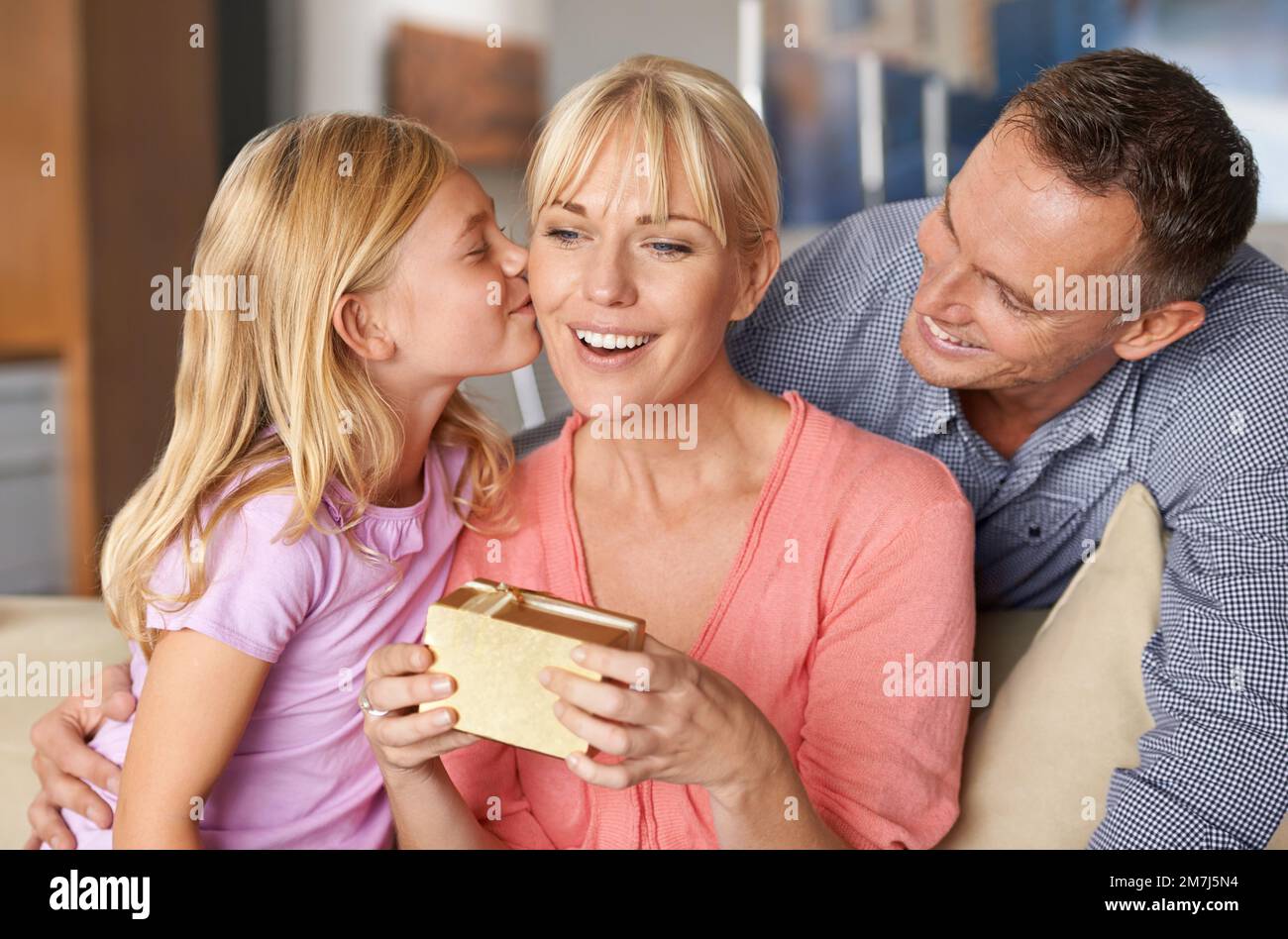 Birthdays are a time to bond. an adorable little girl giving her mom a birthday present. Stock Photo