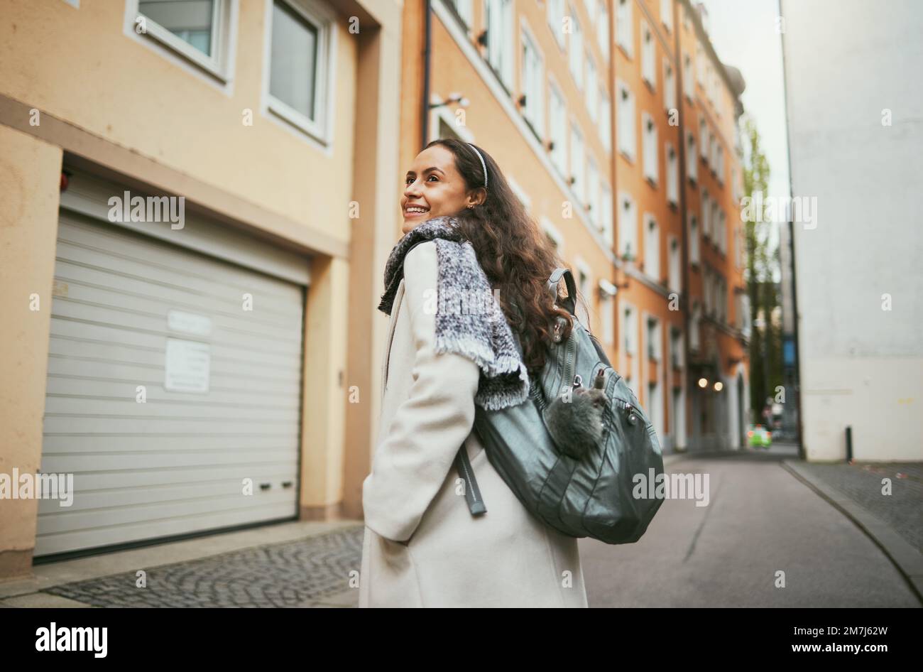 Back, woman and excited for travel, smile and relax for vacation, summer and town. Young female, student exchange or backpack for tourism, happiness Stock Photo