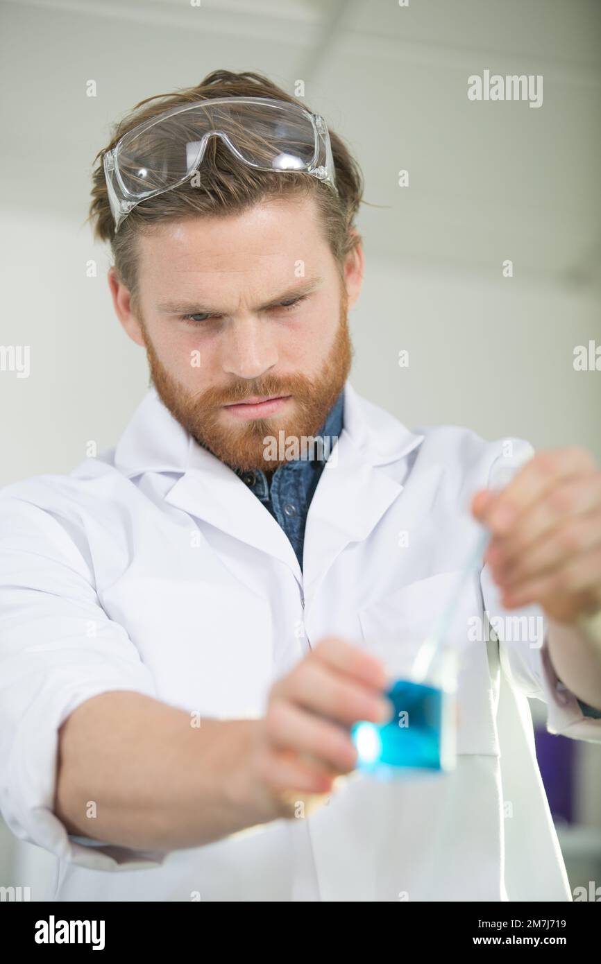a male worker holding liquids in lab Stock Photo Alamy