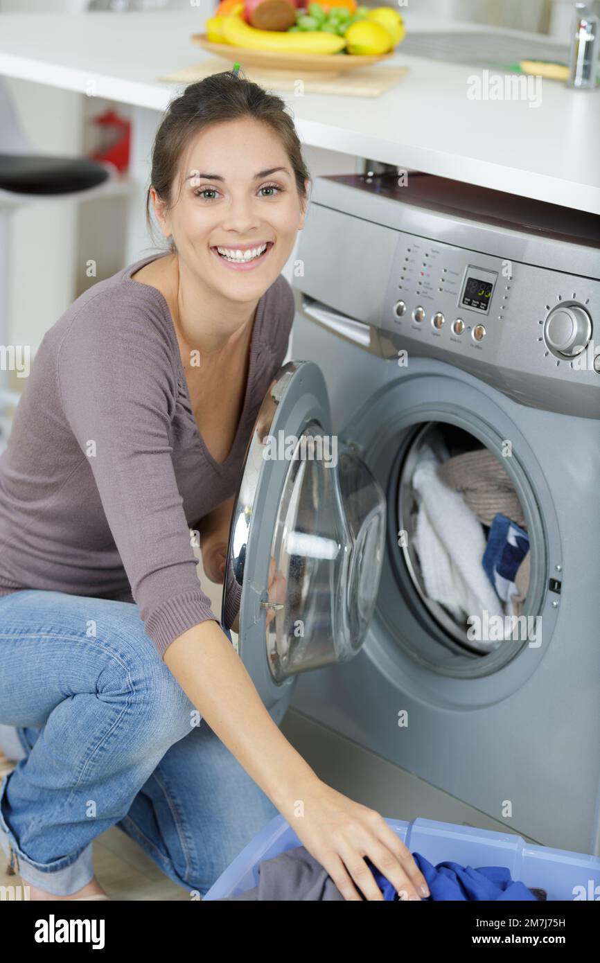 young happy woman emptying a washing machine Stock Photo Alamy