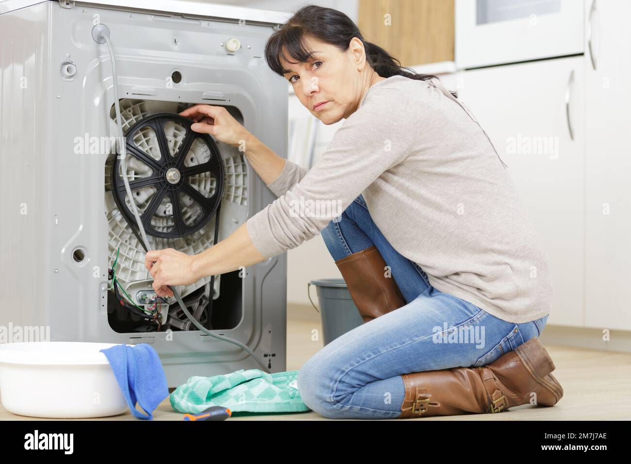 mature woman has a leak in the kitchen Stock Photo - Alamy