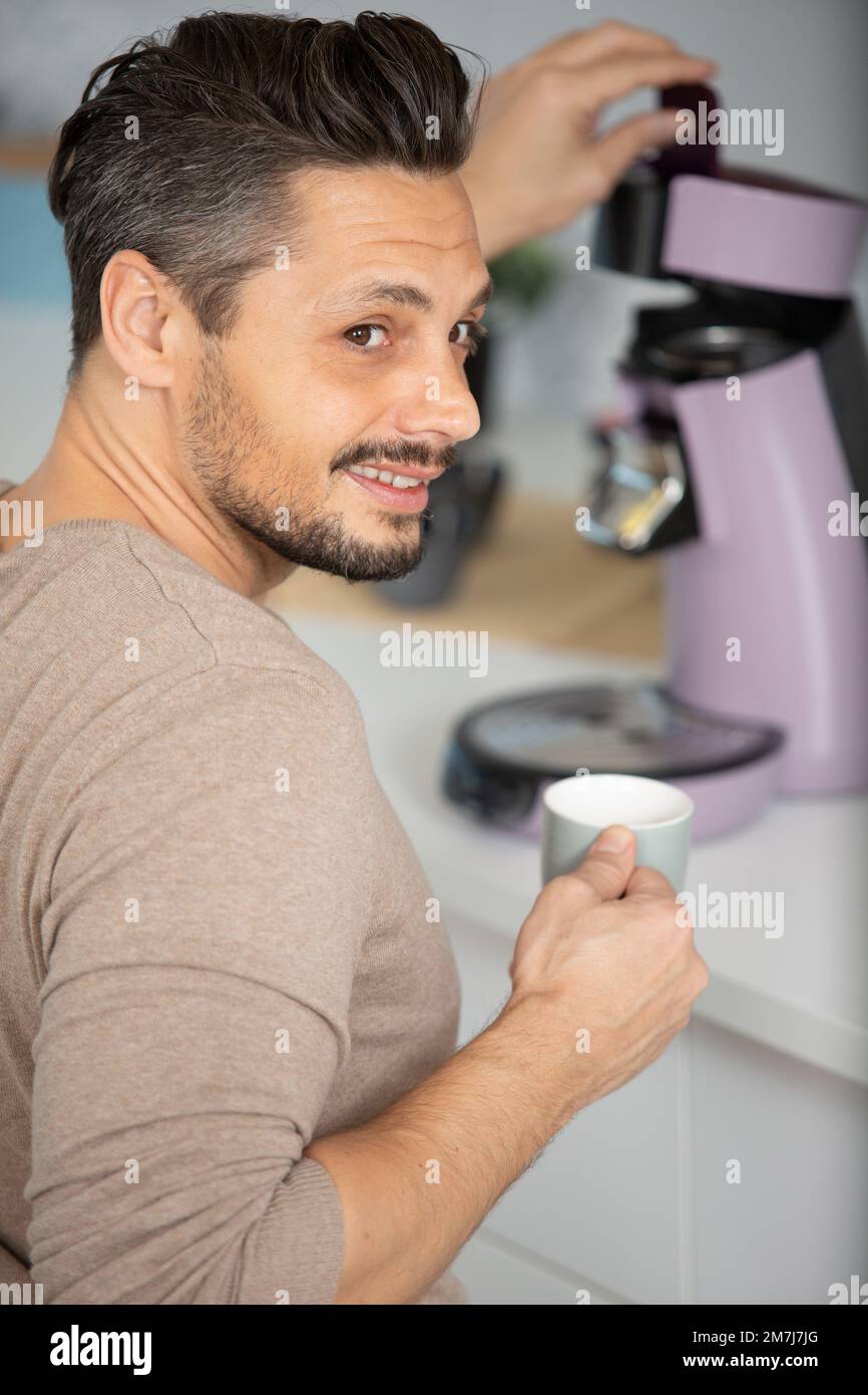 handsome australian man making coffee with a coffee machine Stock Photo
