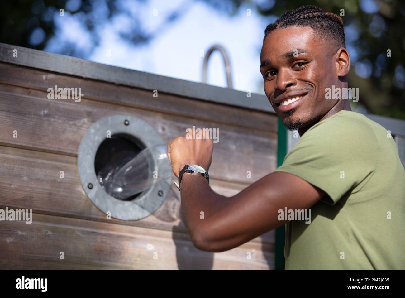 man throwing away plastic bottle in recycling bin Stock Photo Alamy
