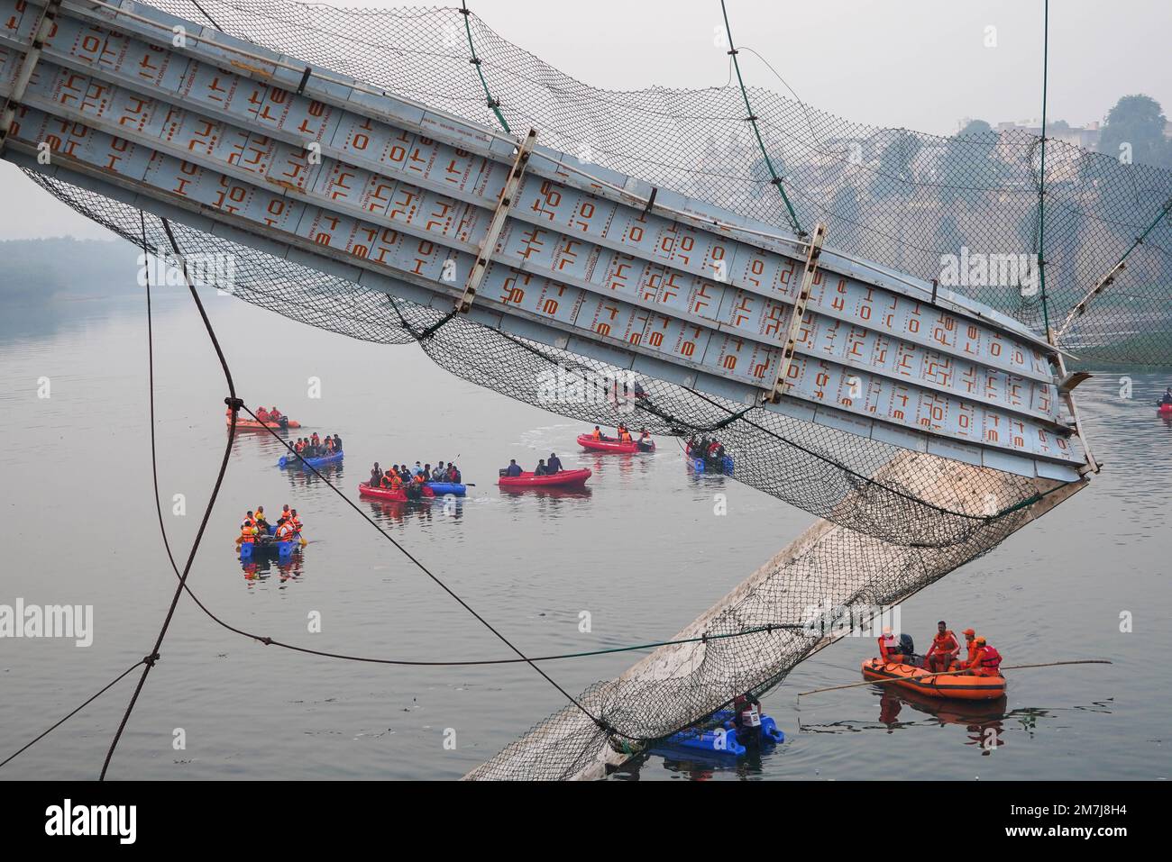 Beijing, China. 10th Jan, 2023. Rescuers on boats search in the Machchhu river after a cable bridge collapsed in Morbi district of India's western state of Gujarat, Oct. 31, 2022. A total of over 100 people were injured in the incident and 177 people were rescued. Credit: Xinhua/Alamy Live News Stock Photo
