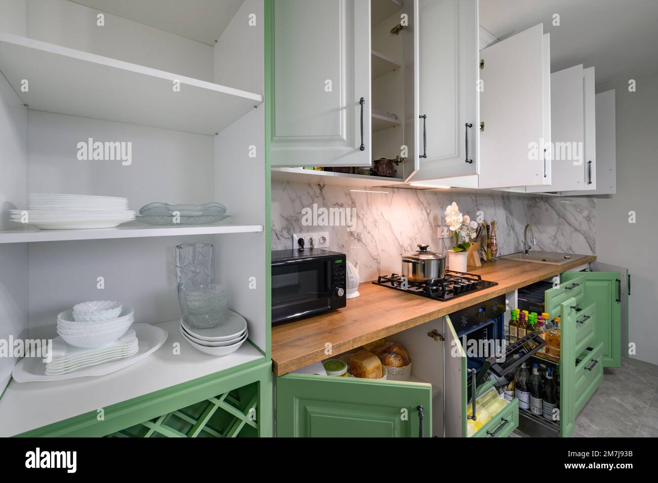 File:White kitchen with cabinet doors and drawers opened or