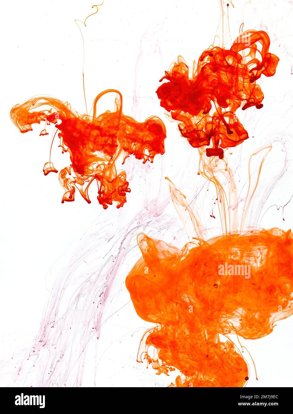 Food colouring swirling through water creating abstract patterns Stock