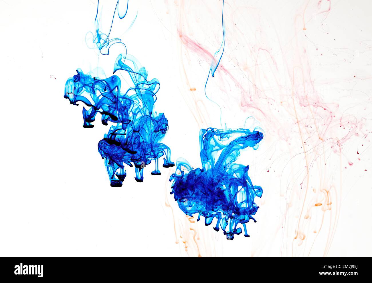 Food colouring swirling through water creating abstract patterns Stock