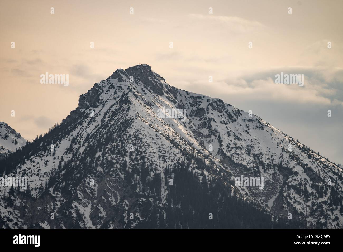 A large mountain covered in snow with a few clouds in the sky Stock ...