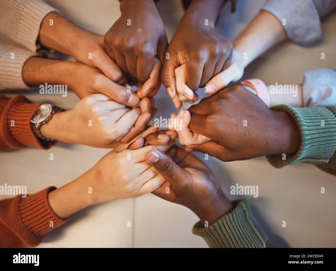Holding hands, top view and group prayer of people with hope, support or faith, religion or spiritual praise. Community, teamwork and Christian Stock Photo