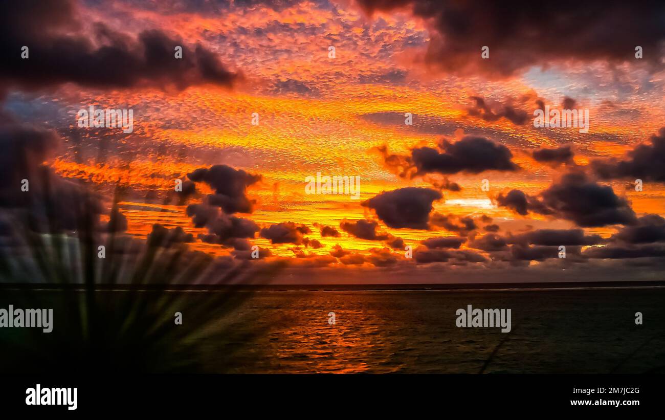 A picturesque sunset sky with fluffy clouds over calm ocean Stock Photo ...