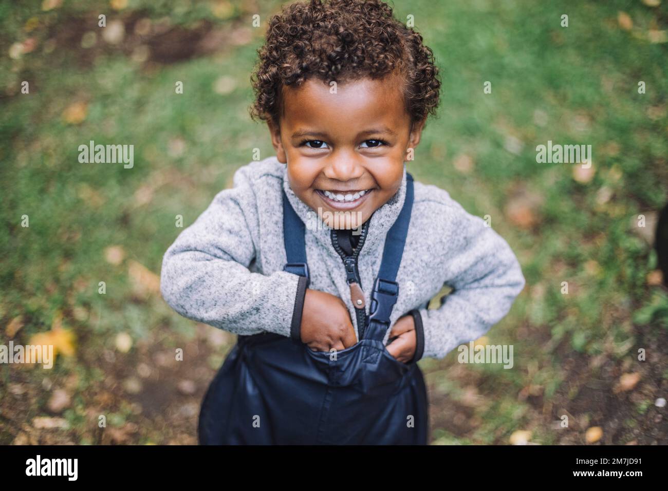 Portrait of happy boy standing in park Stock Photo