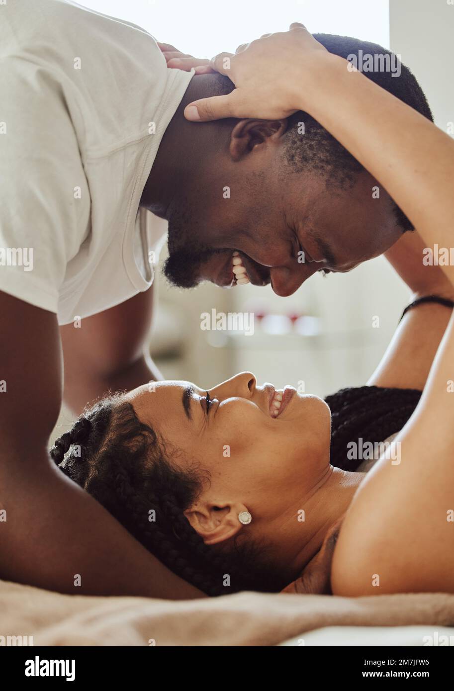 Black couple, love and home bedroom romance while happy and intimate together on bed at home, apartment or hotel photo
