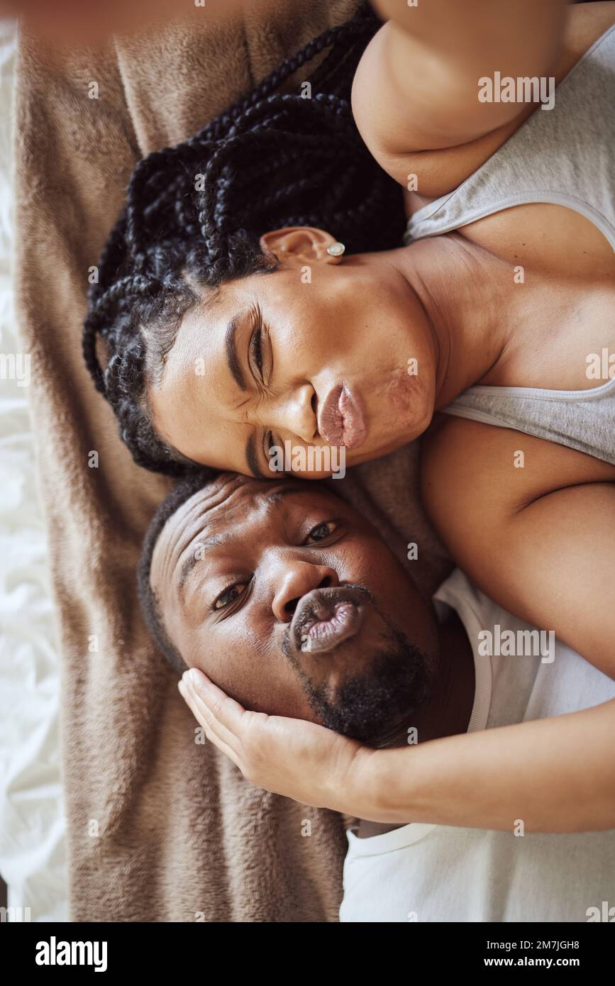 Black couple, love and bedroom selfie while happy and funny together, pouting on bed at home, apartment or hotel picture
