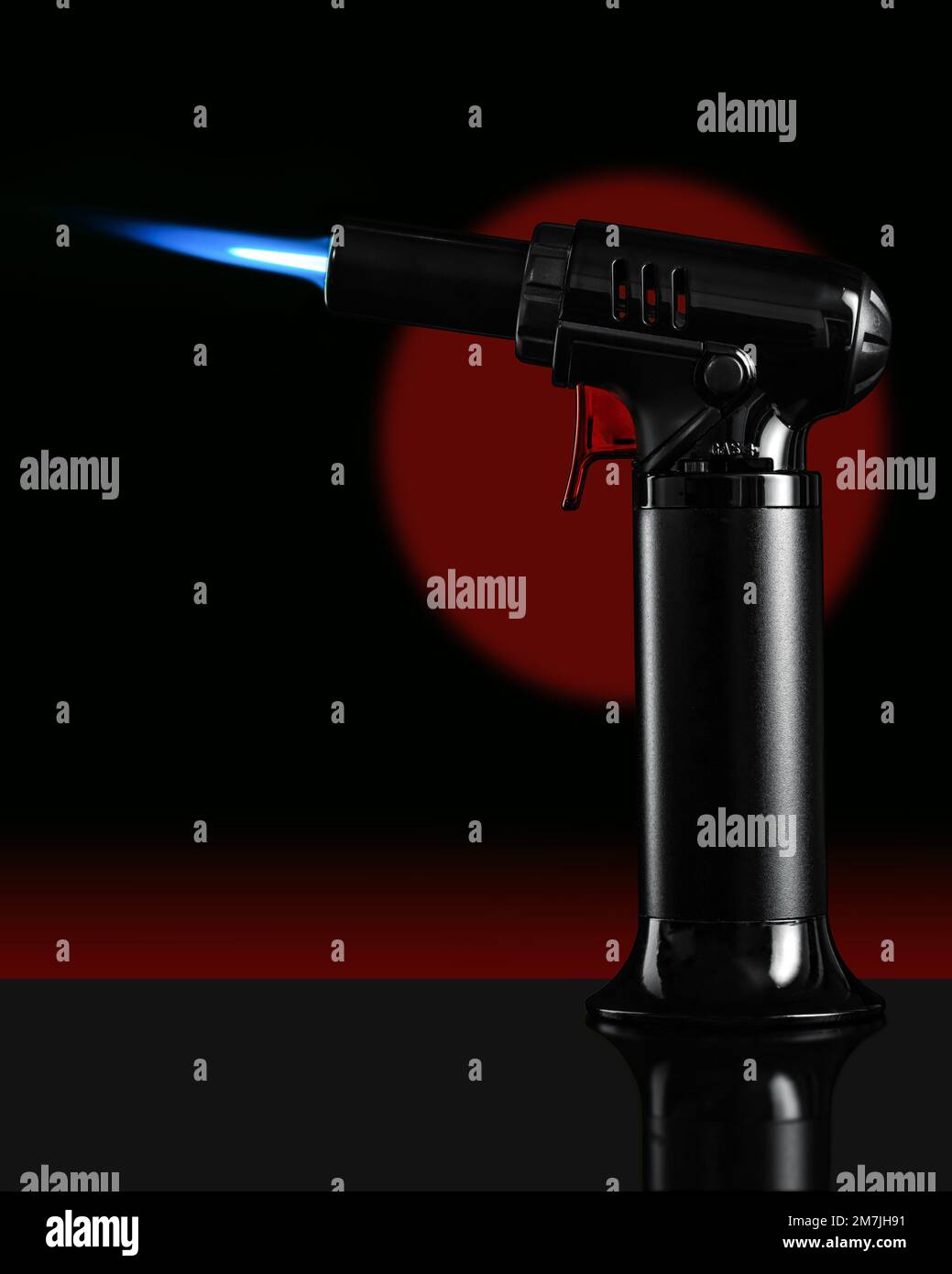 A gas blow torch kitchen with blue flame on the black background Stock