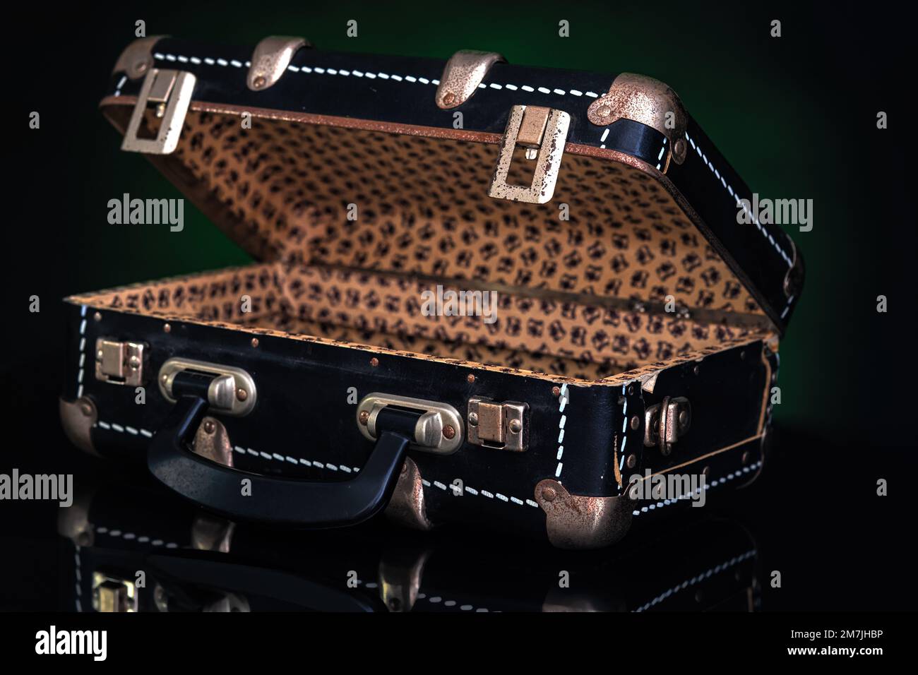Retro, vintage open suitcase on a dark background. Stock Photo