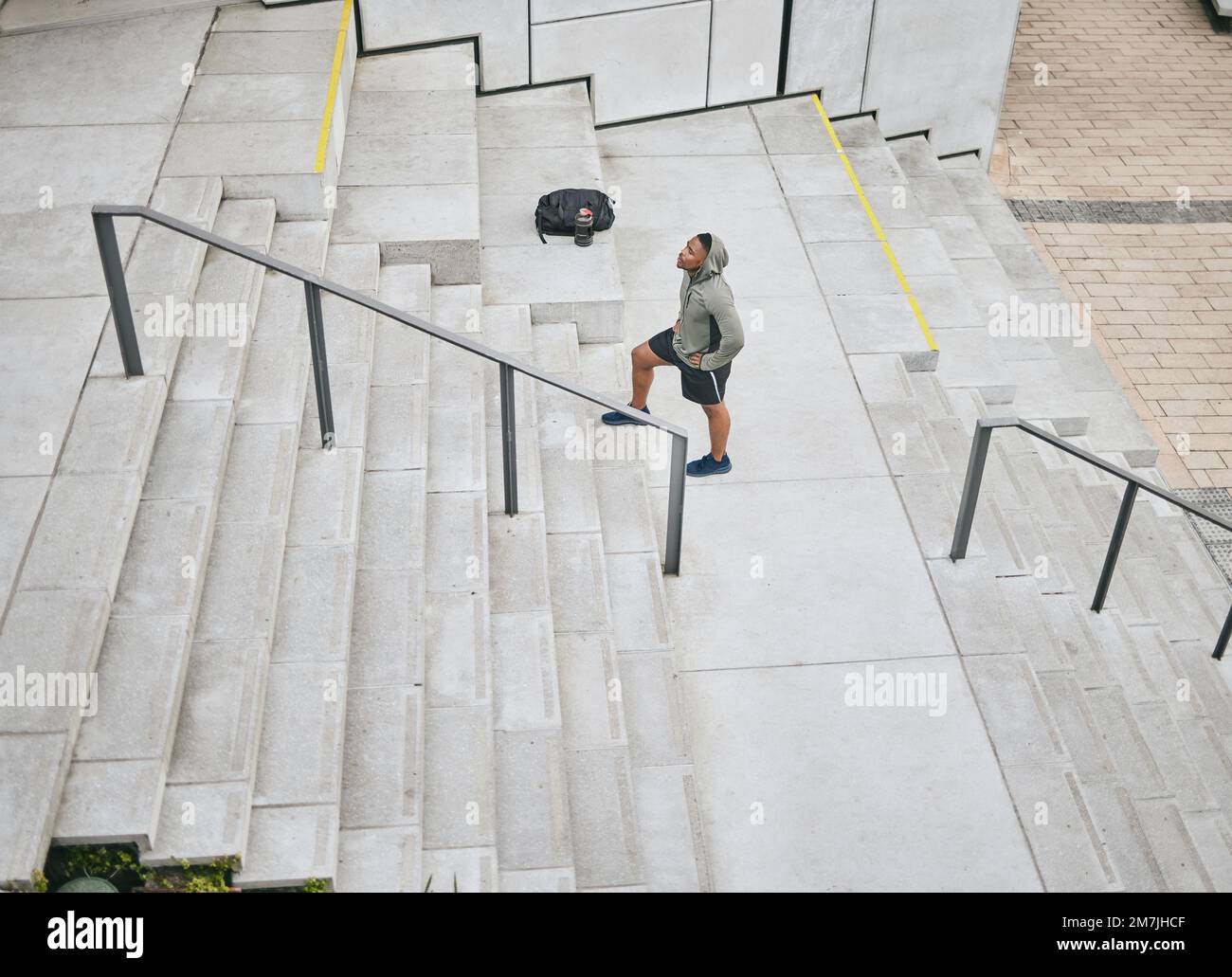 Fitness, tired or black man walking on stairs for training, exercise or cardio workout in Chicago, USA. Mission, mindset or healthy athlete in hoodie Stock Photo