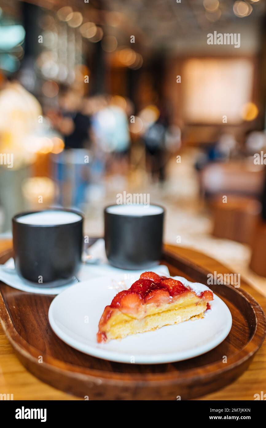 Strawberry Tart and Two Cappuccino Coffee Starbuck Mugs Served on a Tray in Starbucks Reserve Roastery Shop, Milan Italy Stock Photo