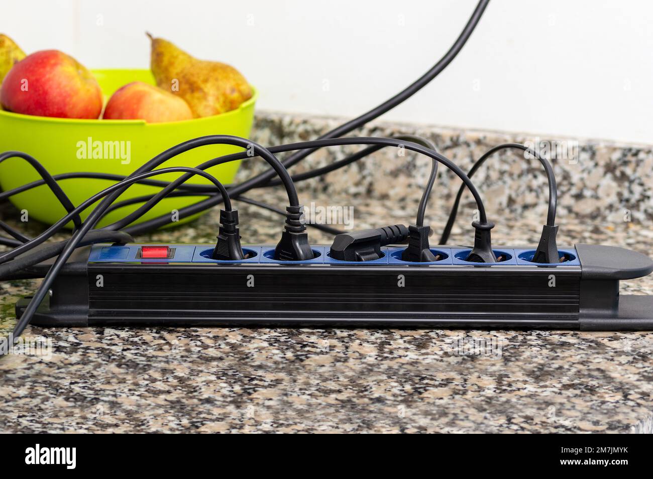 Close up of a plug in an electrical socket on a tabletop at kitchen