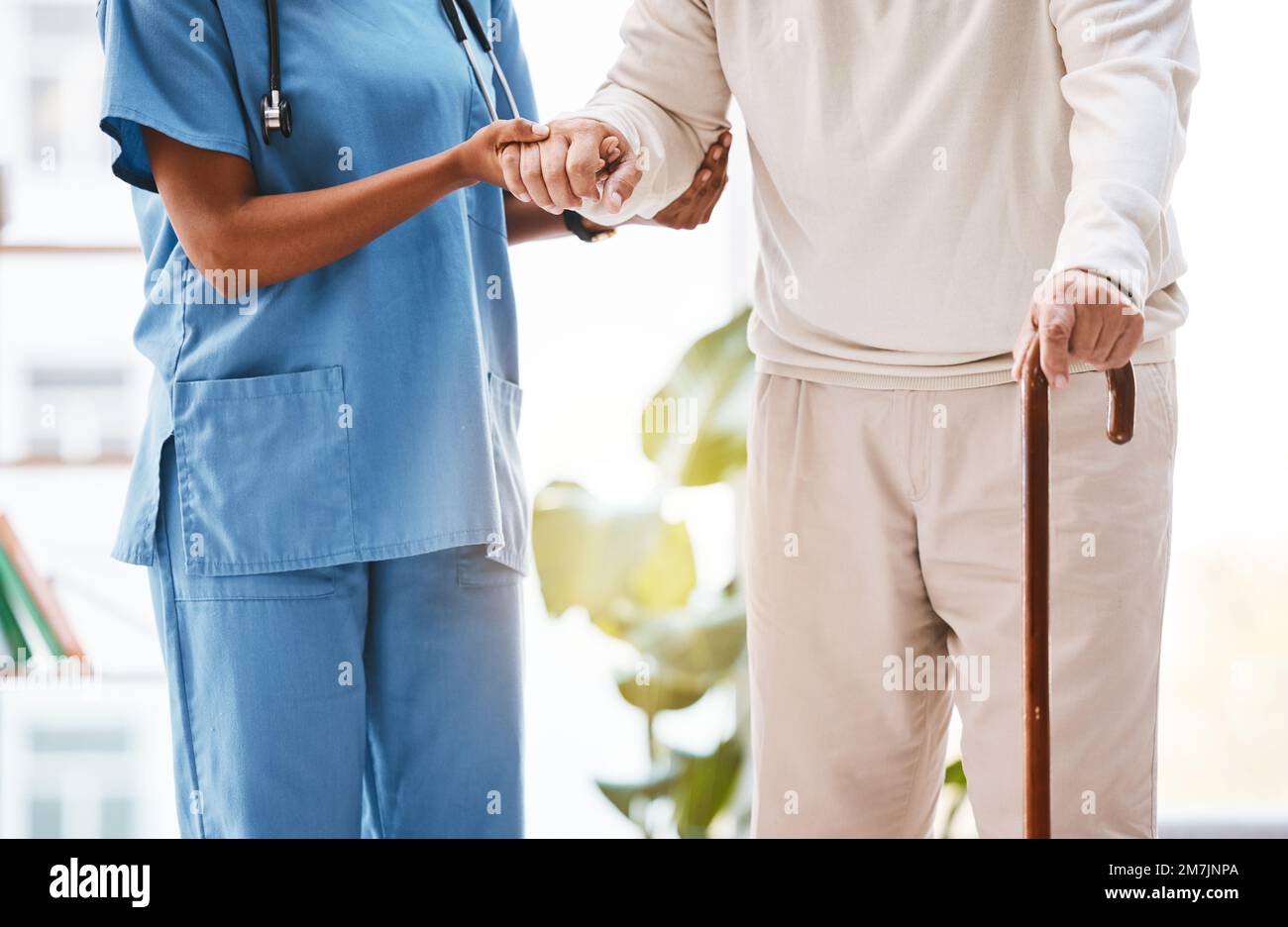 Nurse, disability and old man with walking stick in nursing home for