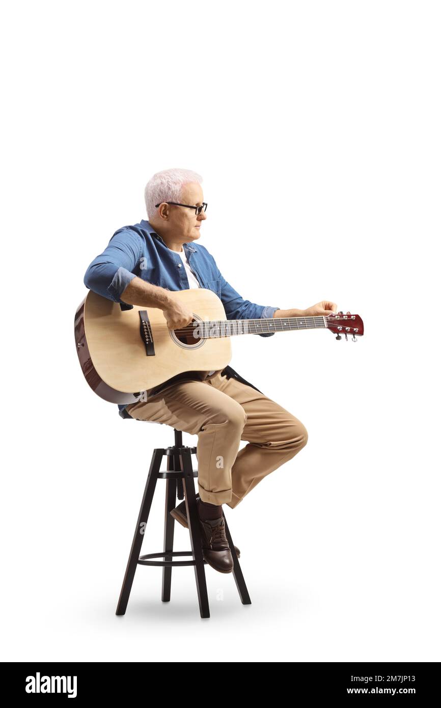 Mature man sitting on a chair playing an acoustic guitar isolated on ...